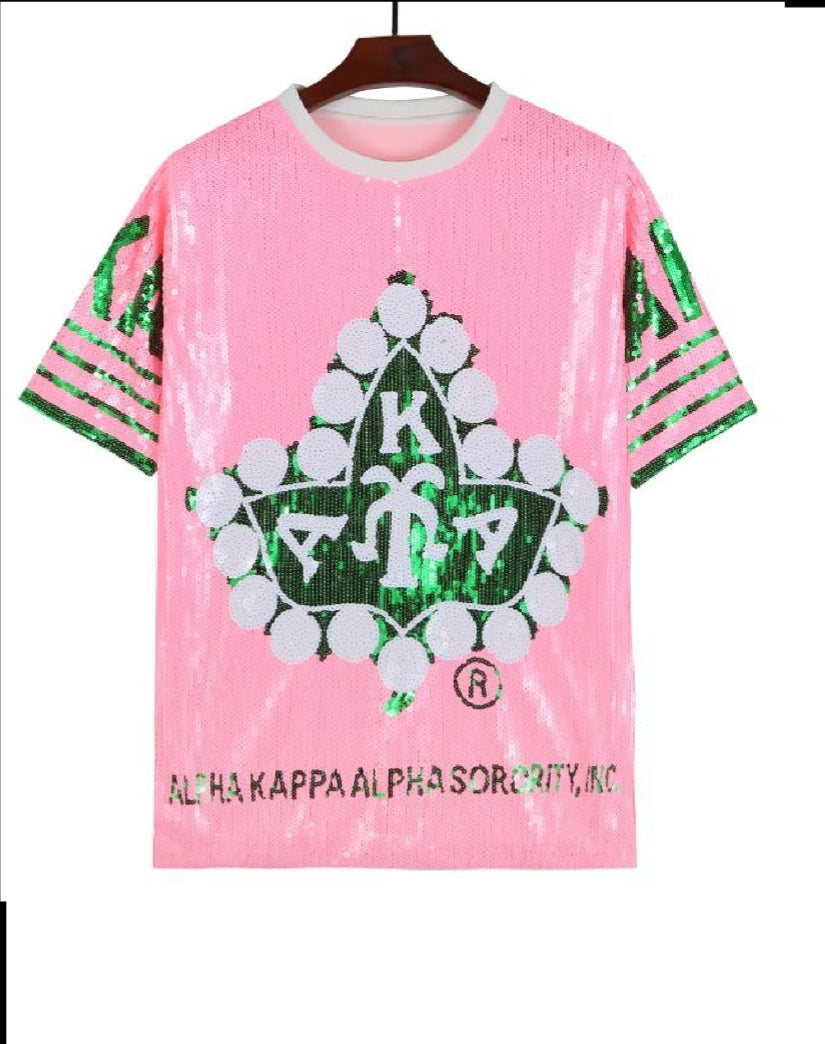 Alpha Kappa Alpha sorority sequence dress in pink, featuring a large graphic symbol.